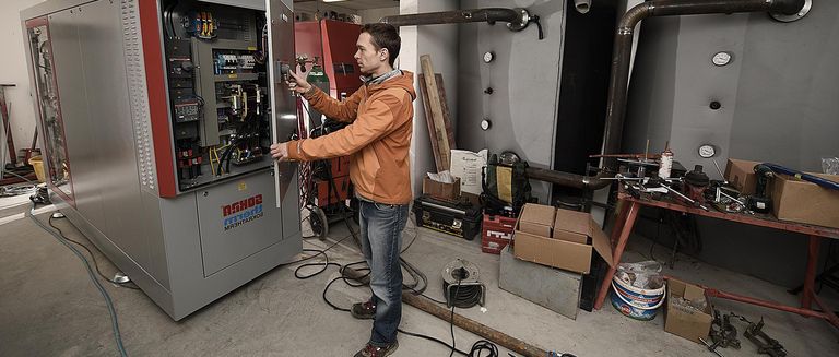 Ingenieur von NaturEnergie prüft Wärmeanlage in einer Heizzentrale in Münstertal, Wärme- und Energielösungen
