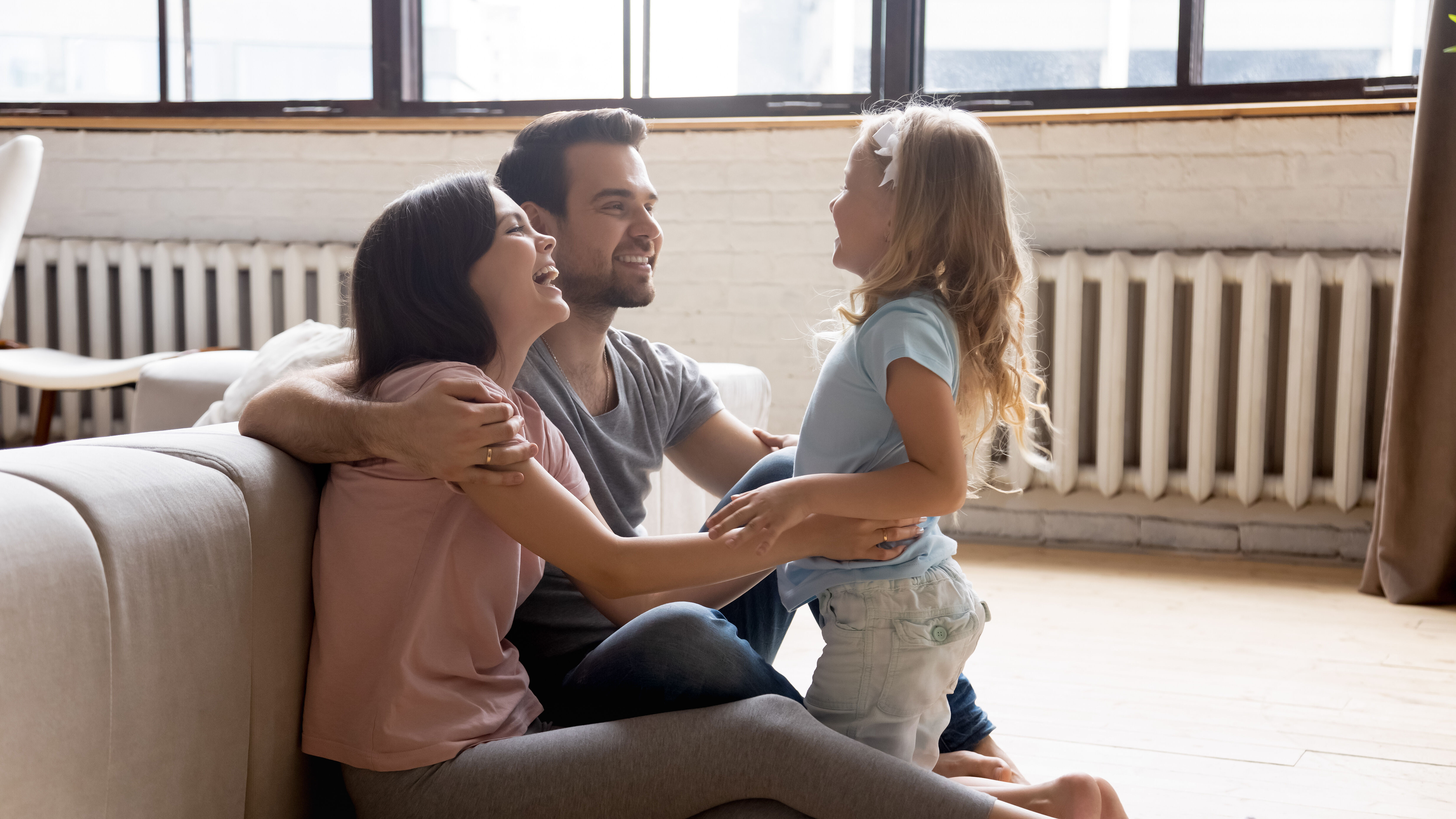 Familie im Wohnzimmer mit Heizkörpern