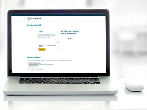 Onlineportal Laptop Auf dem Bild ist ein Laptop zu sehe, der auf einem Tisch steht. Links neben dem Laptop steht eine grüne Kaffeetasse. Der Laptop ist aufgeklappt, auf dem Monitor ist das Login-Fenster des naturenergie Kundenportals zu sehen.