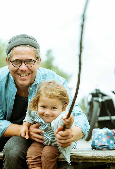 Ein Papa macht mit seiner Tochter einen Ausflug in die Natur und angelt