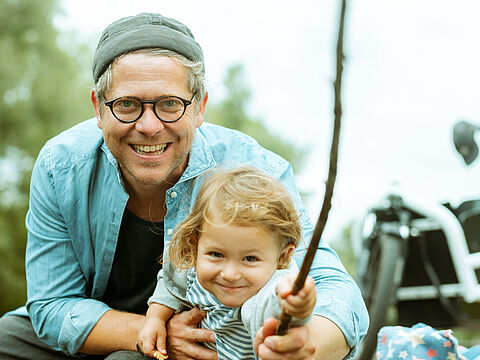 Ein Papa macht mit seiner Tochter einen Ausflug in die Natur und angelt
