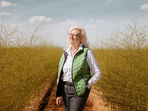 Frau im Feld die in die Weite blickt