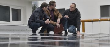 NaturEnergie Team auf PV-Dach NaturEnergie Solar-Team auf dem PV-Dach, diskutiert über die Solaranlage