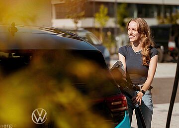 Elektroauto wird geladen im urbanen Umfeld Person lädt Elektroauto in städtischer Umgebung mit Ladekabel