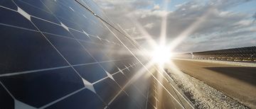 Kraftwerk mit erneuerbarer Sonnenenergie mit Sonne im Hintergrund