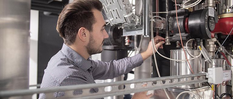 Techniker prüft energieeffiziente Anlagen im Energiedienst-Gebäude. Das Bürohaus in Rheinfelden ist nach dem Platin Standard der Deutschen Gesellschaft für Nachhaltiges Bauen errichtet und durch den Ersatz von Ölheizungen konnte Energiedienst den CO2-Ausstoß durch Öl von 2011 bis 2019 um mehr als 86 Prozent senken.