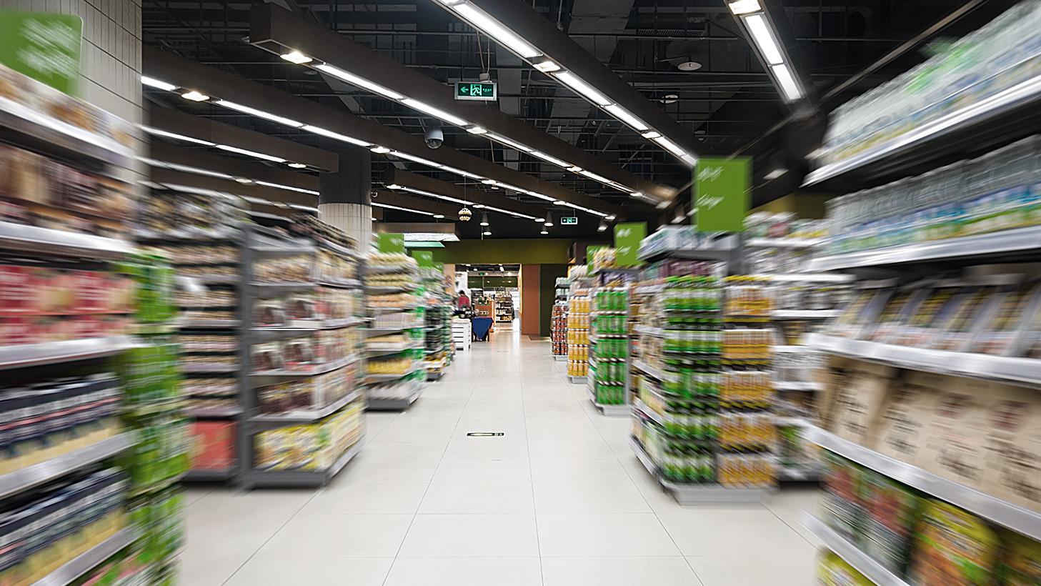 Innenansicht eines Supermarktes mit befüllten Regalen und einer LED-Beleuchtung