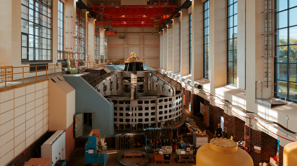 Große Industriehalle mit Turbinenanlage und Krananlage in einem Kraftwerk.