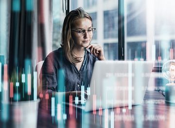 Junge Frau, die in modernen Büros arbeitet. Technische Preisdiagramme und Anzeiger, rote und grüne Kerzenhalter-Karte und Stock-Trading-Computer-Hintergrund. Doppelte Exposition. Händleranalyse