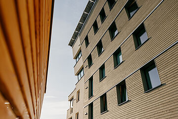 Modernes Gebäude mit Holzfassade und Solarpaneelen auf dem Dach