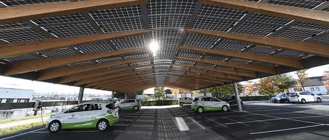 NaturEnergie Photovoltaik-Carport my-e-cars von NaturEnergie stehen unter einem Photovoltaik-Carport, die Sonne strahlt durch das Dach durch.