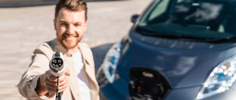 Man zeigt Stecker zum Laden von Elektroautos in die Kamera. Selektiver Fokus