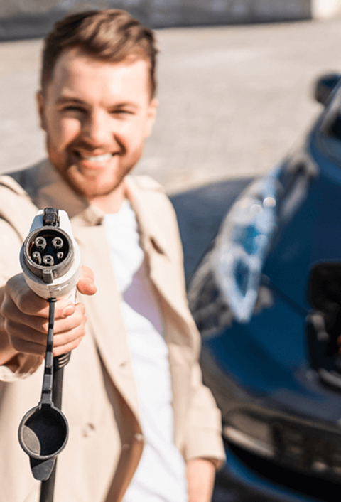 Man zeigt Stecker zum Laden von Elektroautos in die Kamera. Selektiver Fokus