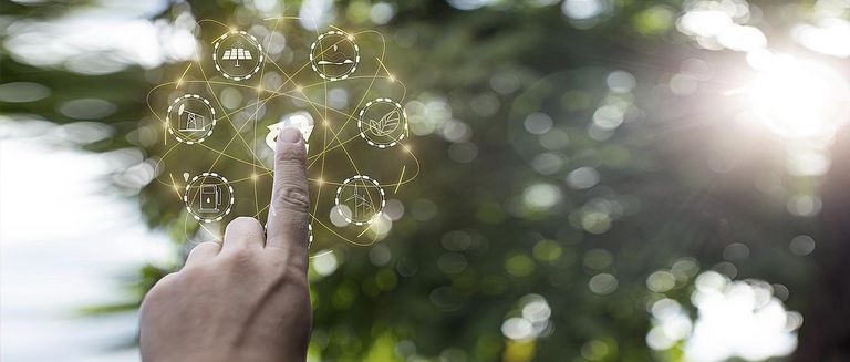 Technologie-Hologramm, Hand zeigt auf Umwelt-Symbole mit Netzwerkverbindung auf grünem Hintergrund.