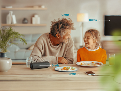 Zwei Personen an einem gedeckten Tisch Zwei Personen sitzen an einem Tisch mit Essen, Tasse und Kamera