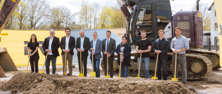 Menschen auf einer Baustelle bei einem Spatenstich