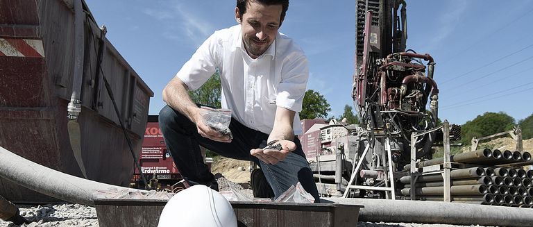 Nahwärme in Murg, Ingenieur von NaturEnergie prüft Material auf der Baustelle bei sonnigem Wetter 