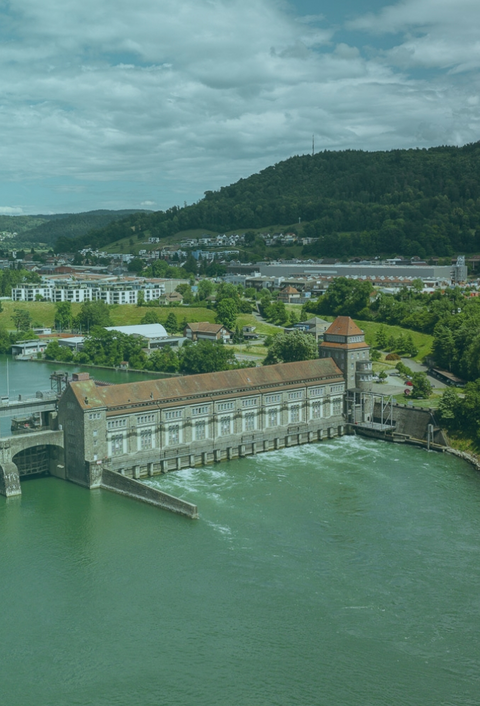 Auf dem Bild ist aus der Vogelperspektive ein Wasserkraftwerk zu sehen 